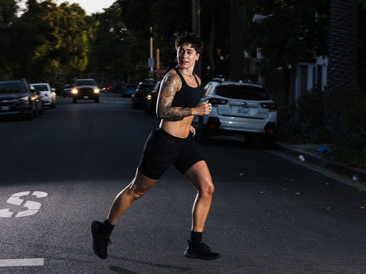 Morgan Olson running across a Los Angeles street at dusk in black shorts and a black sports bra
