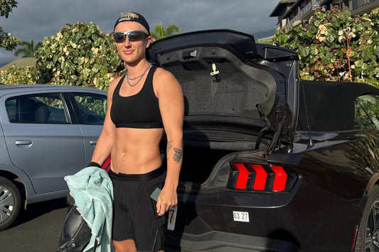 Morgan Olson standing by an open car boot in Hawaii, lean and relaxed, in a black bra and shorts