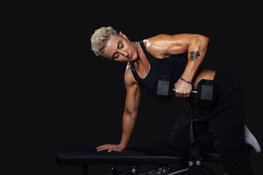 lifter performing a single-arm dumbbell row braced on a bench against a black background