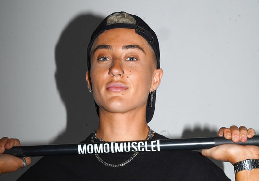 lifter holding a MoMo Muscle barbell at chest height, looking straight at the camera
